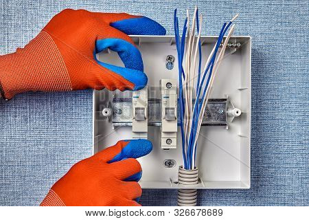 The Repairman Installs A New Electrical Panel With Automatic Fuses For The Household Electric Networ