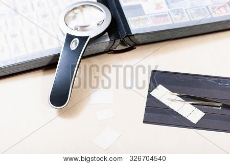 Philately Background - Postage Stamps And Stamp Collecting Items On Pale Wooden Table