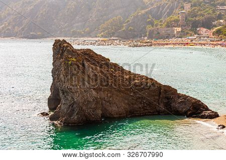 Huge Triangle Shape Rock In The Water On The Beach With Famous Cityscape Of Monterosso Al Mare And H