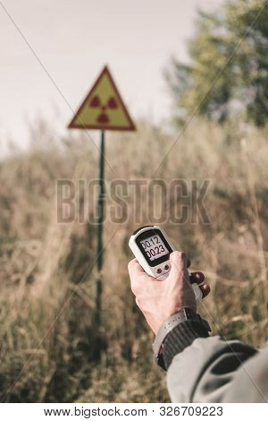 Cropped View Of Man Holding Radiometer Near Toxic Symbol, Post Apocalyptic Concept