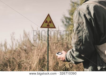 Cropped View Of Man Holding Radiometer Near Toxic Symbol, Post Apocalyptic Concept