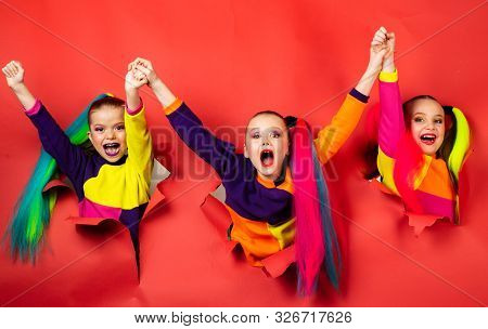 Back To Party. Cute Industrious Children Are Breaking Through Color Paper Wall. Kids Holding Hands H