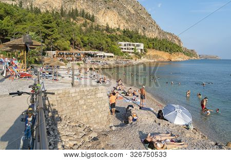 Beachgoers At Arvanitia Beach In Greece.