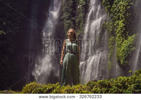 Woman In Turquoise Dress At The Sekumpul Waterfalls In Jungles On Bali Island, Indonesia. Bali Trave