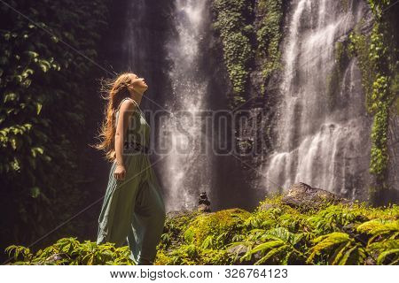 Woman In Turquoise Dress At The Sekumpul Waterfalls In Jungles On Bali Island, Indonesia. Bali Trave