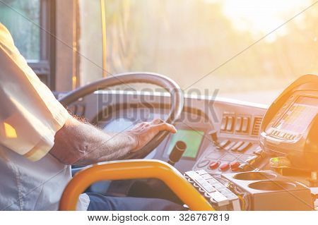 Hands Of Driver In A Modern Bus By Driving. Concept Of Bus Driver Steering Wheel And Driving Passeng