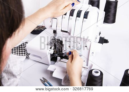Overlock. The Woman Sews The Knit Fabric On The Overlock