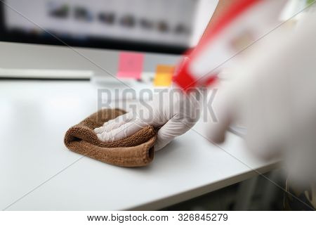 Focus On Cleaner Hand Holding Rag And Wiping Table In Modern Office. Workplace Interior With Modern 