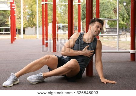 Young Man Having Heart Attack On Sports Ground