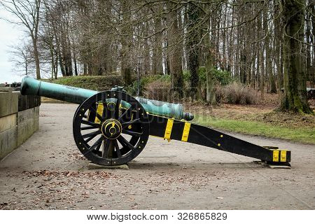 An Antique Cannon On A Lafette In A Castle