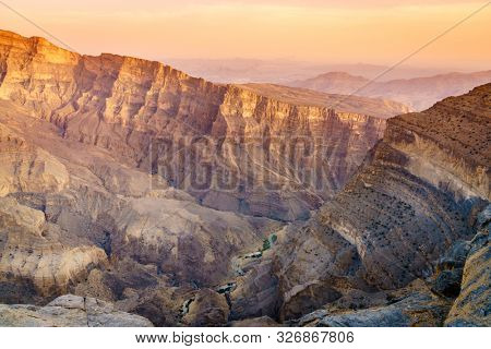 Scenic view of Wadi Ghul aka Grand Canyon of Arabia in Jebel Shams, Oman at sunset