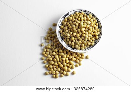 A Pile Of Dried Soybeans In A Dish And On White Background
