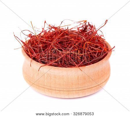 Red chili pepper threads in the wooden bowl, isolated on white background. Lot of whole red chili pepper threads.