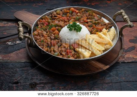 Turkish food lamb meat saute, sac kavurma with rice and french fries isolated on rustic wooden table