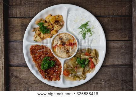 Mix plate arabic food with vegetarian spread starters isolated on rustic wooden background