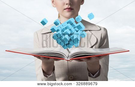 Young Woman Holding Open Book With Flying 3d Blue Cubes. Hi-tech Concept With Virtual Reality Elemen