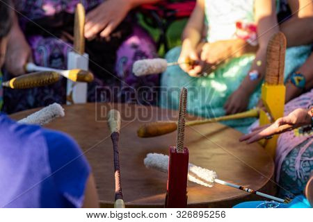 A Close Up View During A Traditional Singing Circle Where Participants Gather Round A Mother Drum An