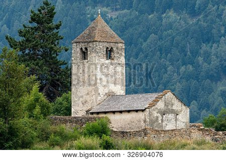 Old Chapel St. Sisinius In Laas (south Tyrol, Italy) On A Cloudy Day In Summer. This Is One Of The O