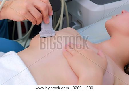 Ultrasound Scanning Diagnostic Of Woman Mammary Glands In Clinic, Closeup View. Doctor Man Runs Ultr