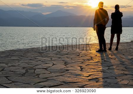 Silhouettes Of Couple Caught By Setting Sun 11standing On Craxy Paving Rock Path Looking Into Sun Ac