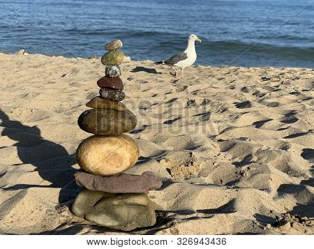 Pebbles Stacked On Malibu Beach At Pacific Ocean