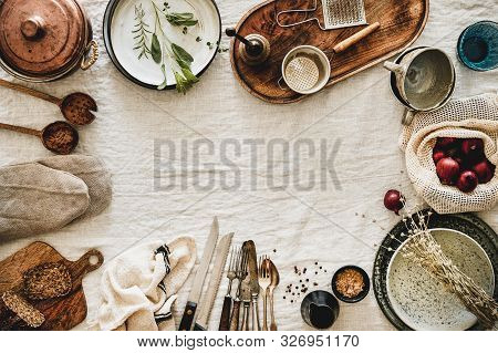 Various Kitchen Utensils And Tablewear Over Linen Tablecloth, Copy Space