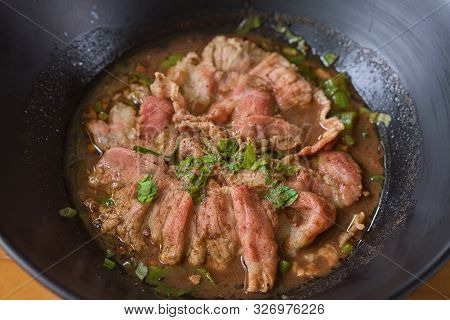 White Noodle Soup With Meatball And Beef Stewed Served In A Black Bowl. In Thailand, We Call This Fo