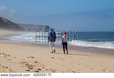 Sao Martinho do Porto, Portugal - July 2, 2021: Couple at the  beach near Sao Martinho do Porto, Portugal