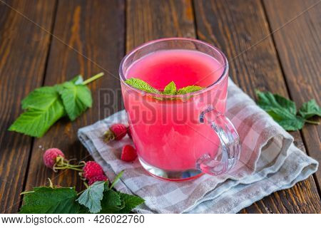 Traditional Russian Hot Drink Raspberry Jelly Or Kissel In A Glass Transparent Mug On A Brown Wooden
