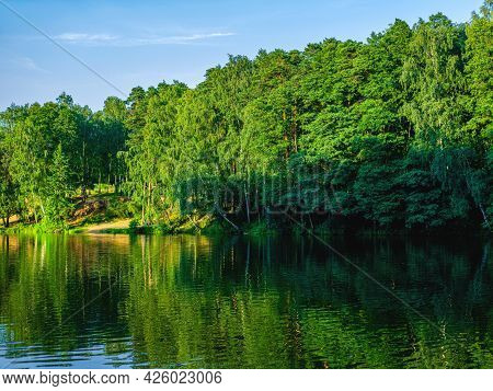The Beautiful And Peaceful View On The River And The Green Trees On Its Bank. The Spring Or Summer B