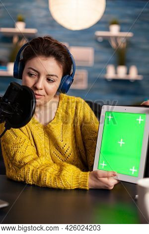 Vlogger Looking At Laptop And Talking About Tablet With Chroma Key Desktop. On-air Production Intern