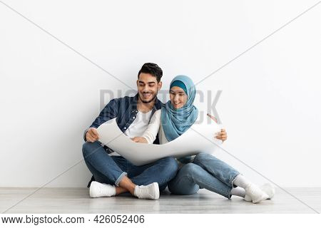 Cheerful Middle-eastern Family With Apartment Scheme, Copy Space