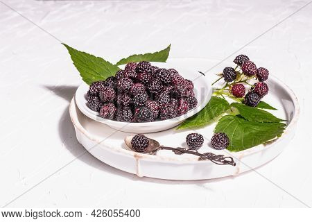 Black Raspberry In A White Bowl. Ripe Organic Fruits On The White Putty Background