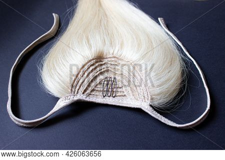 Blonde Natural Hair For Building Up Close-up On A Black Background. A Ponytail Made Of Hair With Dar