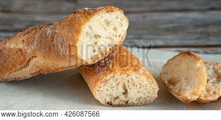 Sliced In Half Baguette. Beautiful Bread Close-up. Fresh Baked Bread Loaf On Wooden Background. Tast