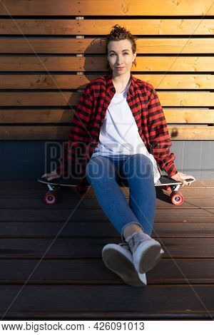 Relaxed Stylish Girl Skateboarder Having Rest After Longboarding Sit On Longboard Skate Smiling. Tre