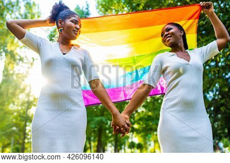 Brazilian Lesbian Couple In White Dress Spending Time Together Celebrating Engagement In Summer Park
