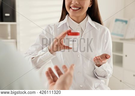 Donor Giving Container Of Sperm To Doctor In Hospital, Closeup
