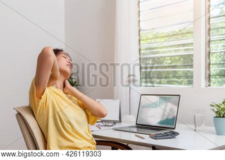 Office Syndrome Concept. Woman Using Hand To Massage Her Neck Feeling Pain In Neck After Working On 
