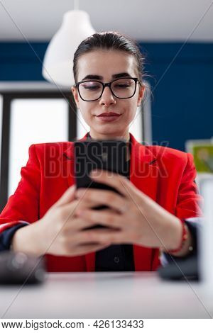 Selective Focus On Smartphone While Businesswoman Is Texting, To Her Assistant. Wwworking In Corpora