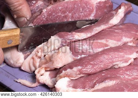 Slice The Pork Or Beef With A Knife On The Table In Close-up.preparation Of Meat Dishes And Food Pro