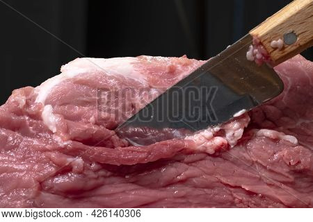 Slice The Pork Or Beef With A Knife On The Table In Close-up.preparation Of Meat Dishes And Food Pro
