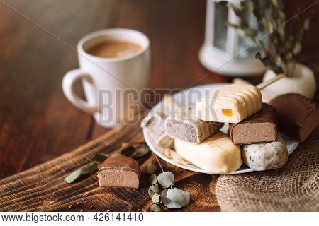 Still Life Of Chocolate Popsicle Lying On A Plate On A Wooden Table