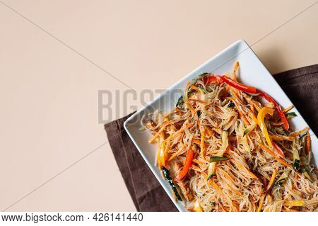 Square Plate With Spaghetti And Meat Salad On Brown Napkin