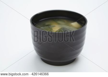 Miso Soup With Seafood In A Black Karelka On White Background.
