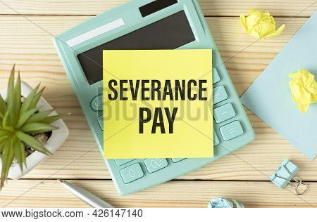 Paper With Severance Pay On The Table, Calculator And Paper Clips On Wooden Background.