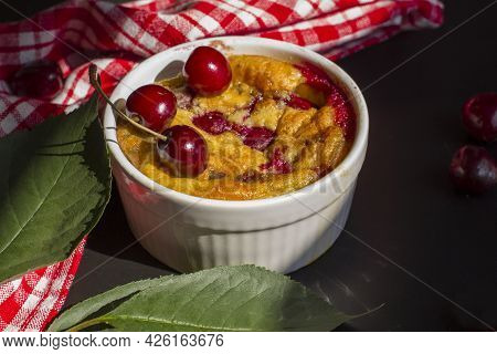 A Portioned Plate With Clafoutis On A Wooden Background On A Bright Sunny Day. Traditional French Pi