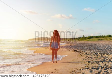 Lonely Young Woman Walking On The Beachsunset Day.beach Woman In Fashion Beachwear Relaxing Walking 