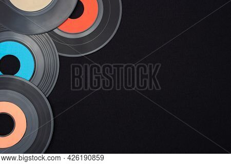 Multi Colored 7 Inch Single Vinyl Records On A Black Background Placed On Top Left Corner With Empty