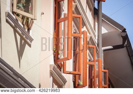 Selective Blur On Open Windows With A Wooden Frame On The Facade Of An Old And Renovated Medieval Bu